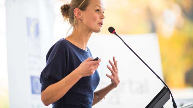 Woman passionately speaking at podium