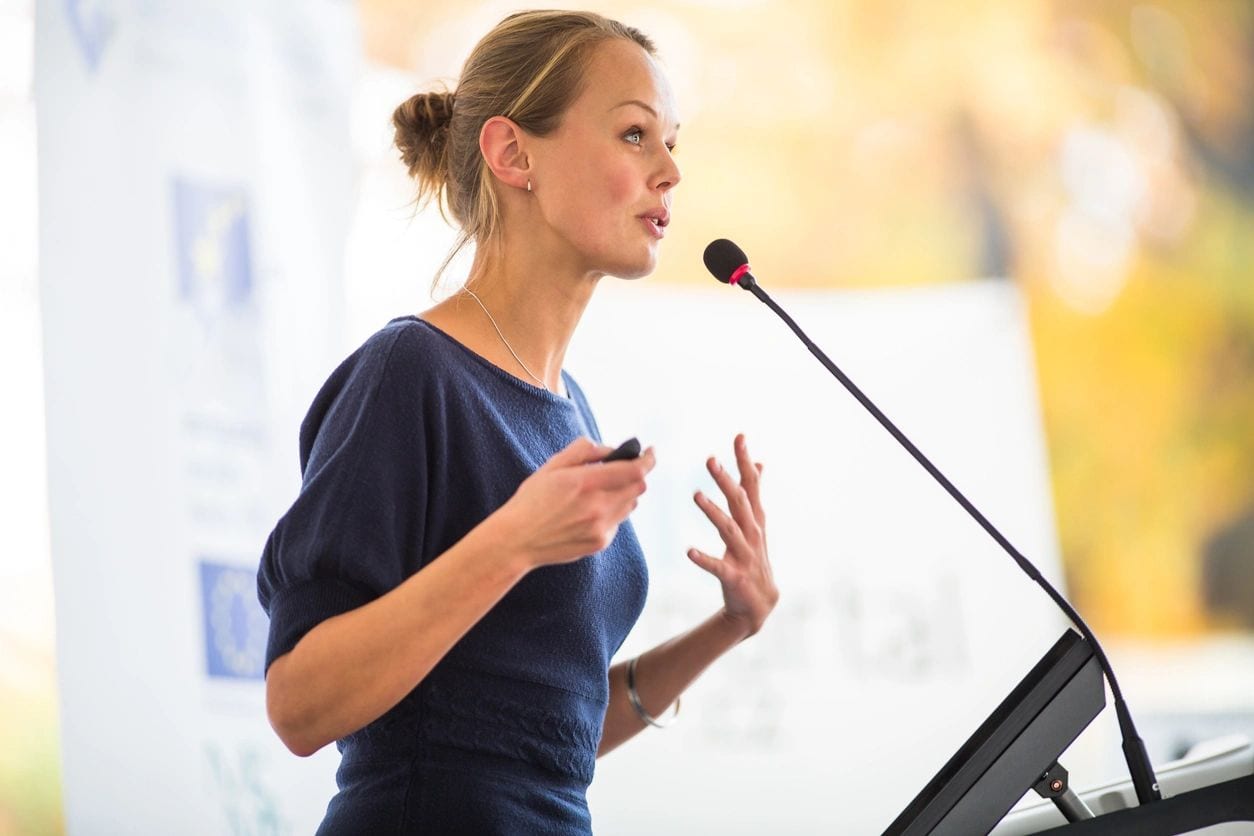 Woman passionately speaking at podium